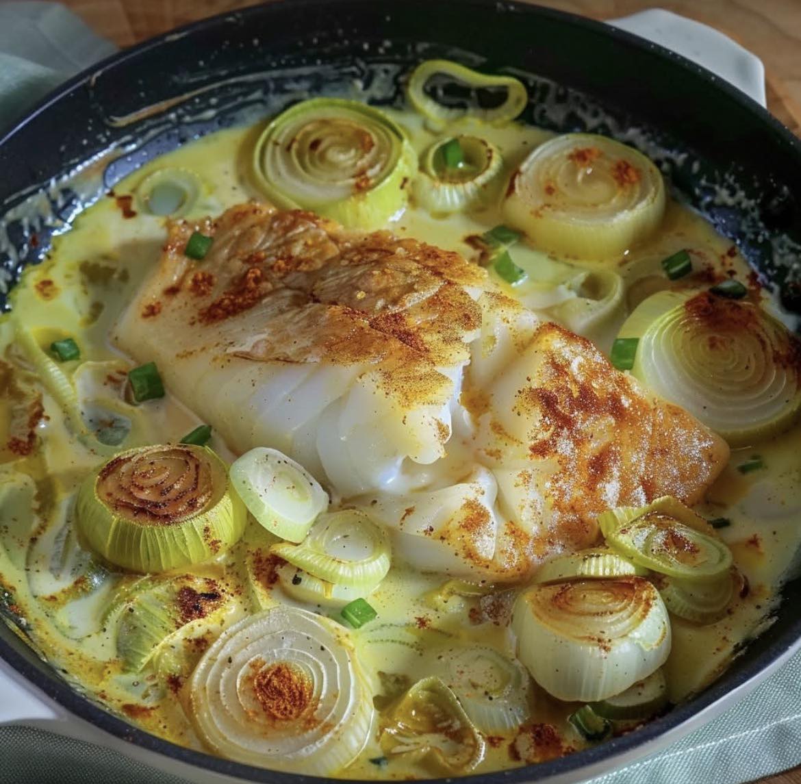 Kabeljauwfilet op een bedje van prei en champignons in romige botersaus
