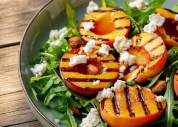Frisse zomersalade met warme perzik, knapperige amandelen en feta met balsamicodressing