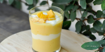 Verkoelende mango smoothie met yoghurtlaag en verse mango